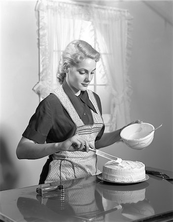 simsearch:846-06111877,k - 1940s WOMAN IN KITCHEN WEARING APRON FROSTING CAKE INDOOR Foto de stock - Con derechos protegidos, Código: 846-06111871