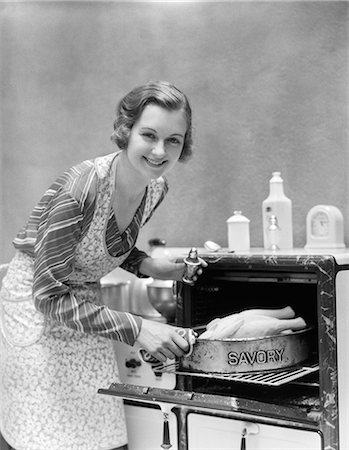 embossed - 1930s HOUSEWIFE IN APRON TAKING TURKEY IN PAN READING SAVORY OUT OF OVEN LOOKING AT CAMERA Stock Photo - Rights-Managed, Code: 846-06111884