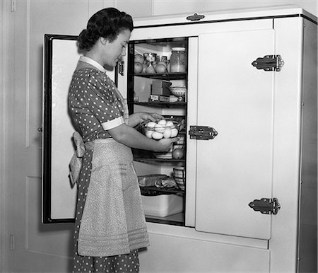 simsearch:846-02793248,k - 1930s HOUSEWIFE IN APRON TAKING EGGS OUT OF BOWL FROM ICEBOX Stock Photo - Rights-Managed, Code: 846-06111887