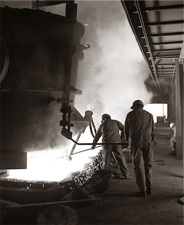 danger smoking - 1960s PAIR OF STEEL WORKERS WEARING HARD HATS STIRRING & STOKING MOLTEN METAL POURING FROM CRUCIBLE Stock Photo - Rights-Managed, Code: 846-06111910