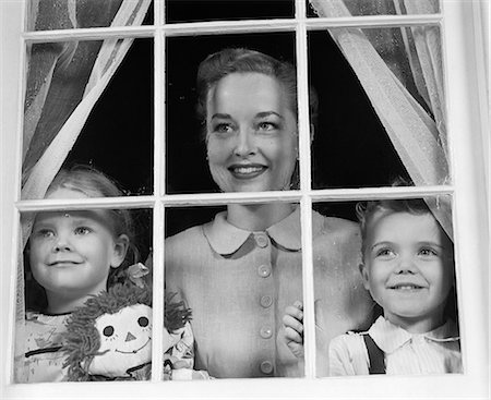 simsearch:846-06112077,k - 1950s MOM WITH TWO KIDS LOOKING OUT WINDOW TOWARDS VIEWER Foto de stock - Direito Controlado, Número: 846-06111948