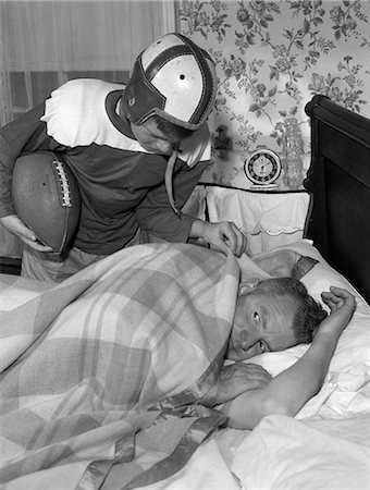 simsearch:846-05647688,k - 1950s BOY IN FOOTBALL UNIFORM WAKING UP FATHER EARLY IN MORNING Stock Photo - Rights-Managed, Code: 846-06111974