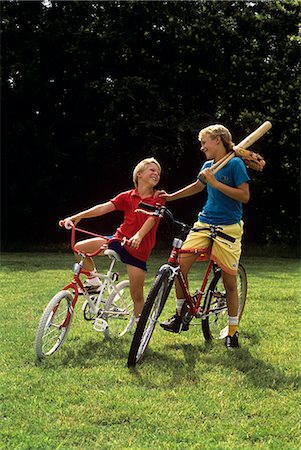 1980s 1990s JUVENILE BOY AND TEENAGE BOY ON BICYCLES WITH BASEBALL BAT AND GLOVE Foto de stock - Con derechos protegidos, Código: 846-06112023
