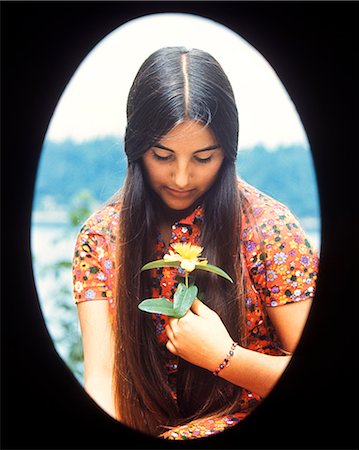 ANNÉES 1970 VIGNETTE OVALE ADOLESCENTE TEEN GIRL MOODY EXPRESSION HOLDING JAUNE FLEURS Photographie de stock - Rights-Managed, Code: 846-06112051