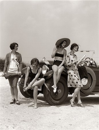 1920s GROUP OF FOUR WOMEN AT SHORE GATHERED AROUND CONVERTIBLE TWO IN DRESSES & TWO IN BATHING SUITS Foto de stock - Con derechos protegidos, Código: 846-06112152