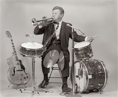 simsearch:846-06111744,k - 1970s ONE-MAN BAND MAN IN TUXEDO BLOWING TRUMPET PLAYING DRUMS BASE DRUM CYMBALS Stock Photo - Rights-Managed, Code: 846-06112201