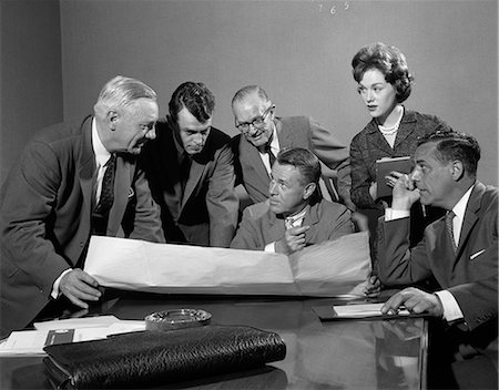 simsearch:846-02797198,k - 1960s GROUP OF 5 EXECUTIVES GATHERED AROUND TABLE WITH SECRETARY TAKING NOTES & PLANS SPREAD OUT BETWEEN THEM Stock Photo - Rights-Managed, Code: 846-06112224