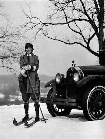 1920s WOMAN ON SKIS STANDING IN FRONT OF CAR PULLING ON GLOVE Stock Photo - Rights-Managed, Code: 846-06112235