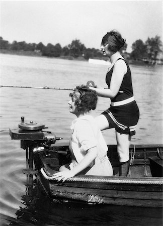 fun black and white photographic images friendship - 1920s 1930s TWO WOMEN FISHING FROM STERN OF SMALL BOAT WITH MOTOR OUTDOOR ONE WOMAN WI WEARING BATHING SUIT Stock Photo - Rights-Managed, Code: 846-06112238