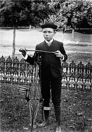 1800s 1890s 1900s TURN OF THE CENTURY BOY STANDING IN YARD NEXT TO OLD FASHIONED BICYCLE Stock Photo - Rights-Managed, Code: 846-06112245