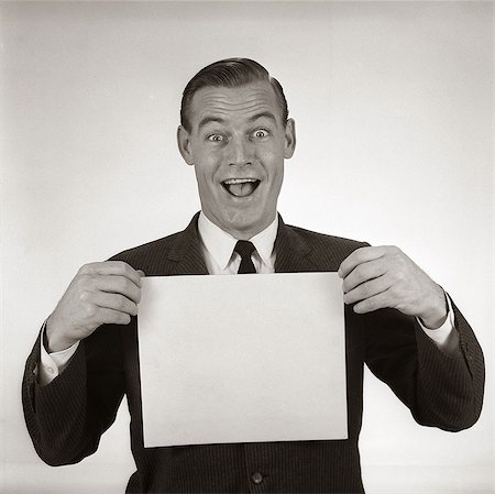 1950s 1960s EXCITED BUSINESSMAN LOOKING AT CAMERA HOLDING BLANK WHITE CARD Stock Photo - Rights-Managed, Code: 846-06112277