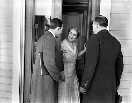 1930s 1940s TWO DOOR-TO-DOOR SALES SALESMEN TALKING TO HOUSEWIFE AT FRONT DOOR MAKING SALES PRESENTATION Stock Photo - Rights-Managed, Code: 846-06112404