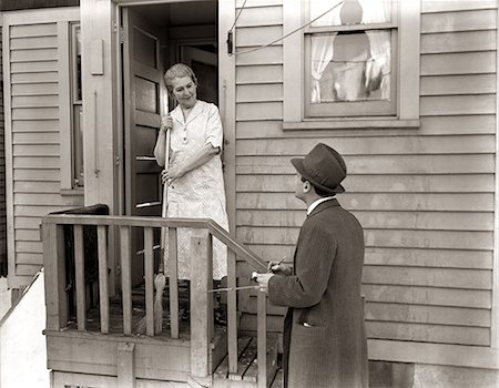 1940s 1930s MAN DOOR-TO-DOOR SALESMAN TALKING WOMAN TO HOUSEWIFE AT BACK DOOR Stock Photo - Rights-Managed, Code: 846-06112403