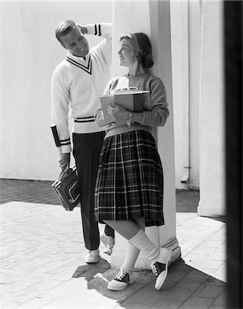 1950s 1960s COLLEGE HIGH SCHOOL AGED TEENAGE BOY & GIRL SMILING FLIRTING WEARING SADDLE SHOES PLAID PLEATED SKIRT TENNIS SWEATER Foto de stock - Con derechos protegidos, Código: 846-06112416