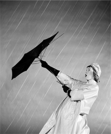 simsearch:846-02796076,k - 1950s WOMAN IN RAIN COAT TRYING TO USE BROKEN UMBRELLA  IN THE WIND Stock Photo - Rights-Managed, Code: 846-06112463