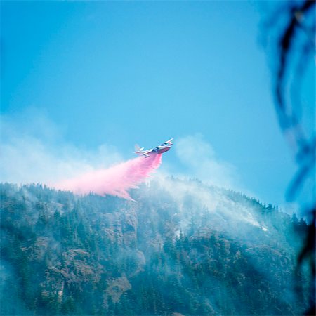simsearch:846-08226095,k - 1970s AIRPLANE DROPPING FIRE RETARDANT OVER FOREST FIRE Foto de stock - Con derechos protegidos, Código: 846-07200094