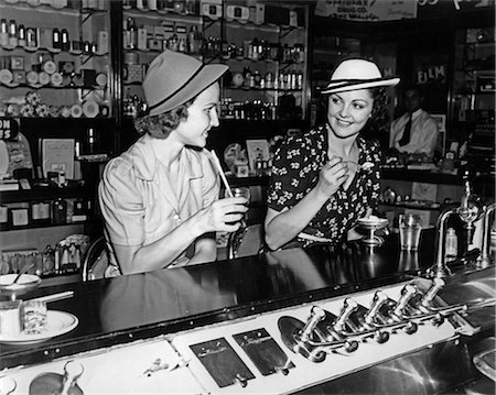 person eating ice cream - 1930s TWO WOMEN DRINKING SODAS EATING ICE CREAM AT SODA SHOP COUNTER Stock Photo - Rights-Managed, Code: 846-07760710