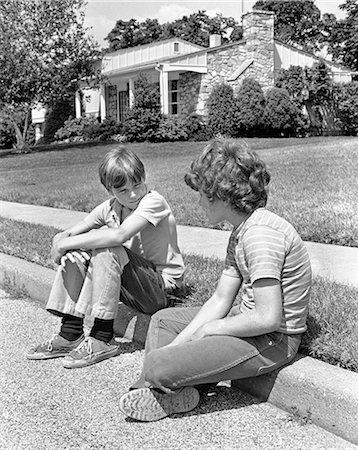 retro teenagers - 1970s TWO EARLY TEENAGE BOYS SITTING ON CURB SUBURBAN NEIGHBORHOOD TALKING Foto de stock - Con derechos protegidos, Código: 846-07760713