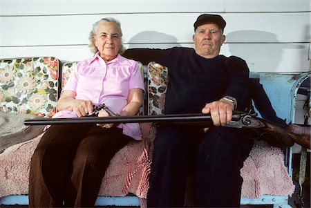 ELDERLY COUPLE WITH SHOTGUN & PISTOL SITTING ON PORCH GLIDER Stockbilder - Lizenzpflichtiges, Bildnummer: 846-07760735