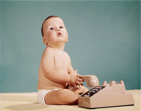 retro facial expressions - 1960s BABY WITH FUNNY FACIAL EXPRESSION HOLDING RECEIVER OF PUSH BUTTON TELEPHONE LOOKING AT CAMERA Stock Photo - Rights-Managed, Code: 846-08030377