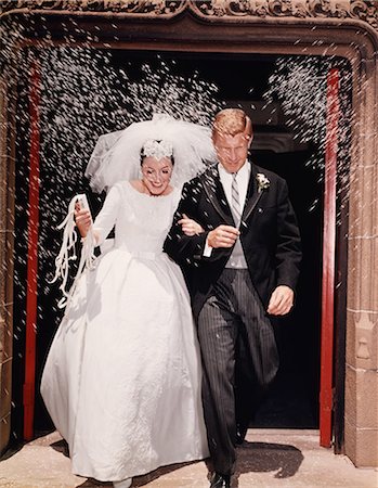 simsearch:846-02792516,k - 1960s JUST MARRIED BRIDE AND GROOM LEAVING CHURCH UNDER SHOWER OF RICE Photographie de stock - Rights-Managed, Code: 846-08030373