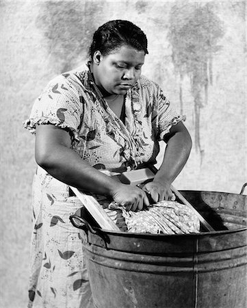 simsearch:846-05648154,k - 1930s AFRICAN-AMERICAN WOMAN WASHING SCRUBBING CLOTHES ON WASHBOARD IN A GALVANIZED ZINC WASHTUB Stock Photo - Rights-Managed, Code: 846-08140082