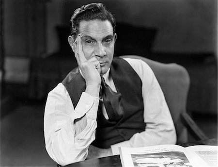 1930s 1940s MAN SEATED ELBOWS ON TABLE FACE LEANING ON HAND SERIOUS EXPRESSION WEARING SHIRT TIE VEST LOOKING AT CAMERA Stockbilder - Lizenzpflichtiges, Bildnummer: 846-08140094