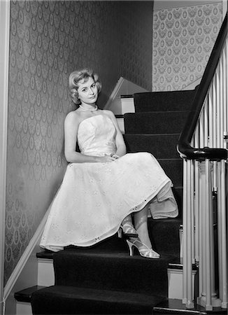 1950s 1960s WOMAN FORMAL COCKTAIL DRESS SITTING ON STAIRS LOOKING SAD WAITING FOR DATE STOOD UP Stockbilder - Lizenzpflichtiges, Bildnummer: 846-08140107