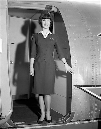 retro vintage occupations adults - 1960s SMILING STEWARDESS STANDING IN DOORWAY OF AIRPLANE LOOKING AT CAMERA Stock Photo - Rights-Managed, Code: 846-08226049
