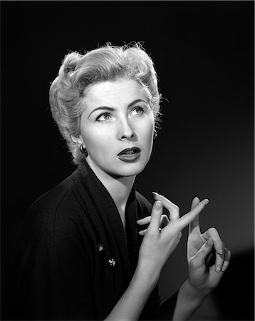 simsearch:846-08226175,k - 1950s THOUGHTFUL BLOND WOMAN COUNTING ON HER FINGERS LOOKING AWAY Stockbilder - Lizenzpflichtiges, Bildnummer: 846-08226084