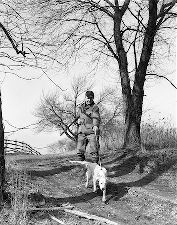 simsearch:846-09085274,k - 1950s MAN HUNTER WITH SHOTGUN AND ENGLISH SETTER DOG ON LEASH Stock Photo - Rights-Managed, Code: 846-08226082