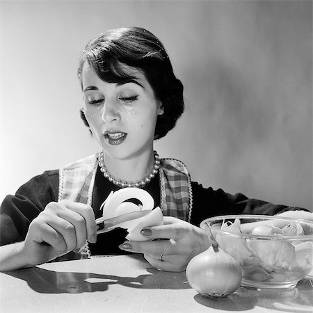 1950s 1960s WOMAN HOUSEWIFE COOK REACTING TO PEELING ONION CRYING TEARS Stock Photo - Rights-Managed, Code: 846-08226101