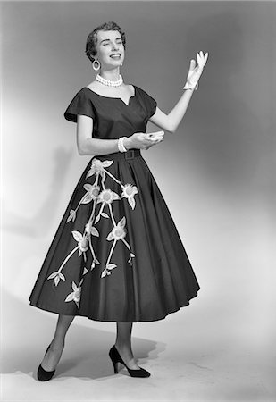 1950s BRUNETTE WOMAN WEARING BLACK DRESS WITH FLOWERS GLOVES PEARL CHOKER Stockbilder - Lizenzpflichtiges, Bildnummer: 846-08226131