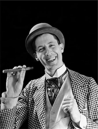 1910s 1920s PORTRAIT SMILING CHARACTER CON MAN BOWLER HAT FANCY SUIT CRAVAT SMOKING CIGAR LOOKING AT CAMERA Stock Photo - Rights-Managed, Code: 846-08226167