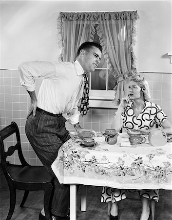 simsearch:846-05645866,k - 1950s COUPLE AT BREAKFAST TABLE MAN WITH HAND ON HIP SUFFERING BACK PAIN Stock Photo - Rights-Managed, Code: 846-08512674