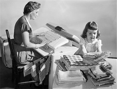 simsearch:700-02912544,k - 1950sHOUSEWIFE PRESSING LINENS AS DAUGHTER FOLDS & STACKS THEM ON TABLE Stock Photo - Rights-Managed, Code: 846-08512700