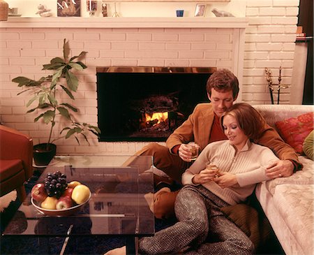 1970s ROMANTIC COUPLE MAN AND WOMAN HAVING DRINKS BY FIREPLACE SITTING ON FLOOR Foto de stock - Con derechos protegidos, Código: 846-08512713