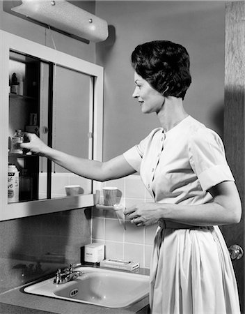 simsearch:846-09012701,k - 1960s BRUNETTE WOMAN TAKING BOTTLE PILLS OUT OF BATHROOM MEDICINE CABINET Photographie de stock - Rights-Managed, Code: 846-08639477