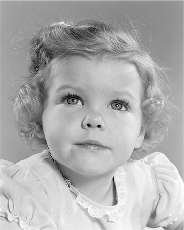1950s SMILING LITTLE GIRL PORTRAIT TODDLER LOOKING UP AT CAMERA Foto de stock - Con derechos protegidos, Código: 846-08639534