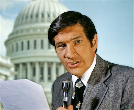 1970s NEWS REPORTER BLACK HAIR SPORT JACKET SPEAKING INTO MICROPHONE LOOKING AT CAMERA CAPITOL WASHINGTON DC USA Photographie de stock - Rights-Managed, Code: 846-08639554