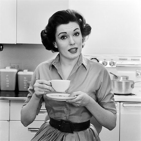 excuses (pardon) - 1950s 1960s PORTRAIT WOMAN HOUSEWIFE IN KITCHEN DRINKING CUP OF COFFEE SPEAKING LOOKING AT CAMERA Photographie de stock - Rights-Managed, Code: 846-08721088