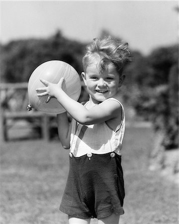 simsearch:846-09181558,k - 1930s SMILING BOY SUMMER OUTDOOR PLAYING IN BACKYARD LOOKING AT CAMERA READY TO TOSS BALL Photographie de stock - Rights-Managed, Code: 846-08721097