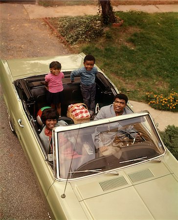 1970s AFRICAN AMERICAN FAMILY OF FOUR SEATED IN CONVERTIBLE CAR FATHER MOTHER SON DAUGHTER LOOKING AT CAMERA Stockbilder - Lizenzpflichtiges, Bildnummer: 846-08721108