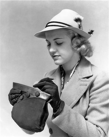 fashion of the 1930s for women - 1930s 1940s BLOND WOMAN WEARING STYLISH HAT LOOKING IN HER HANDBAG WEARING GLOVES AND WINTER COAT Stock Photo - Rights-Managed, Code: 846-08721124