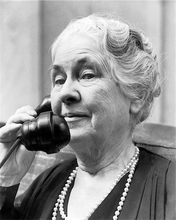 perlenkette - 1930s 1940s OLD WOMAN ON TELEPHONE HEAD AND SHOULDERS GRAY HAIR PEARLS LOOKING AT CAMERA Stockbilder - Lizenzpflichtiges, Bildnummer: 846-08721132