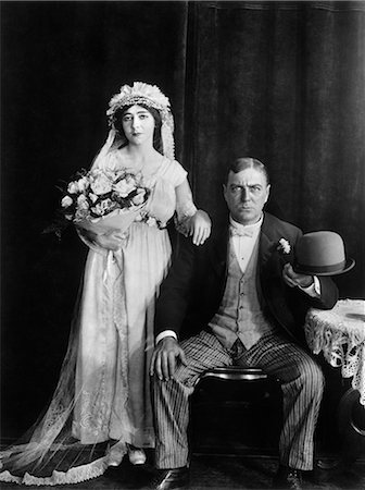 1890s 1910s WEDDING PORTRAIT SERIOUS BRIDE AND GROOM LOOKING AT CAMERA SILENT MOVIE STILL Foto de stock - Con derechos protegidos, Código: 846-09012682