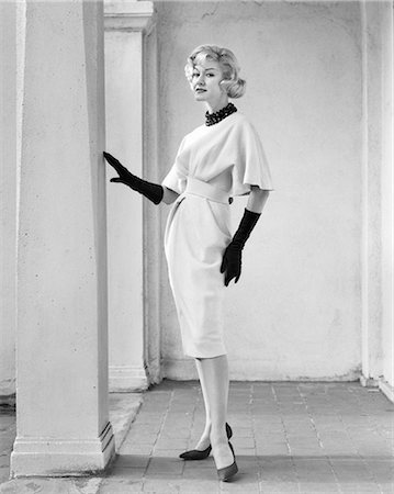 simsearch:846-03165560,k - 1960s FULL LENGTH PORTRAIT ELEGANT BLONDE WOMAN WEARING DRESS WITH FULL DRAPED SLEEVES LONG GLOVES POSING BY COLUMN OUTDOORS Stock Photo - Rights-Managed, Code: 846-09012734