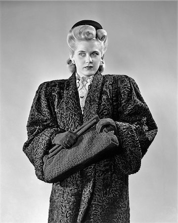 1940s BLOND WOMAN LOOKING OFF TO SIDE WEARING PERSIAN LAMB COAT CLUTCHING HAND BAG FASHION NOIR Foto de stock - Con derechos protegidos, Código: 846-09012736