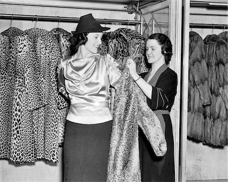 simsearch:846-06111850,k - 1930s SMILING WOMAN IN FUR SALON TRYING ON LEOPARD SKIN COAT WITH HELP FROM SALESWOMAN Foto de stock - Direito Controlado, Número: 846-09012740