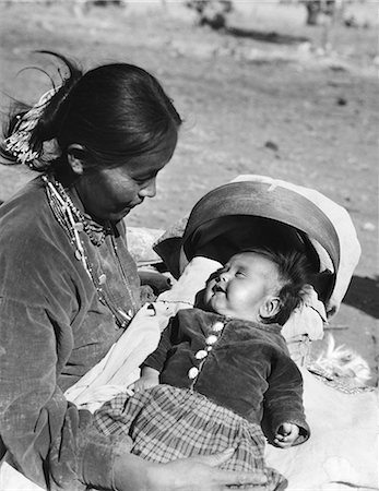 simsearch:846-02793017,k - 1930s NATIVE AMERICAN NAVAJO INDIAN WOMAN MOTHER HOLDING SMILING BABY PAPOOSE IN CRADLE BOARD Stock Photo - Rights-Managed, Code: 846-09012765
